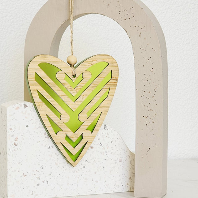 Heart-shaped ornament in lime satin acrylic featuring intricate Koru patterns, perfect for home decor and gifting.