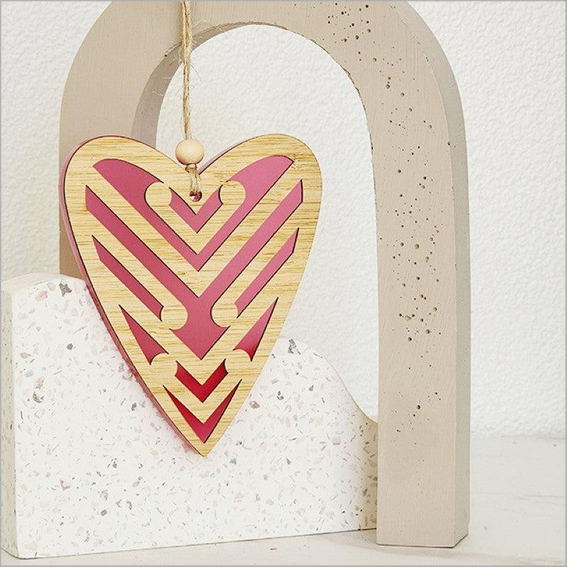 Pink satin acrylic heart ornament with koru designs, symbolizing new beginnings, perfect for home decor or gifts.