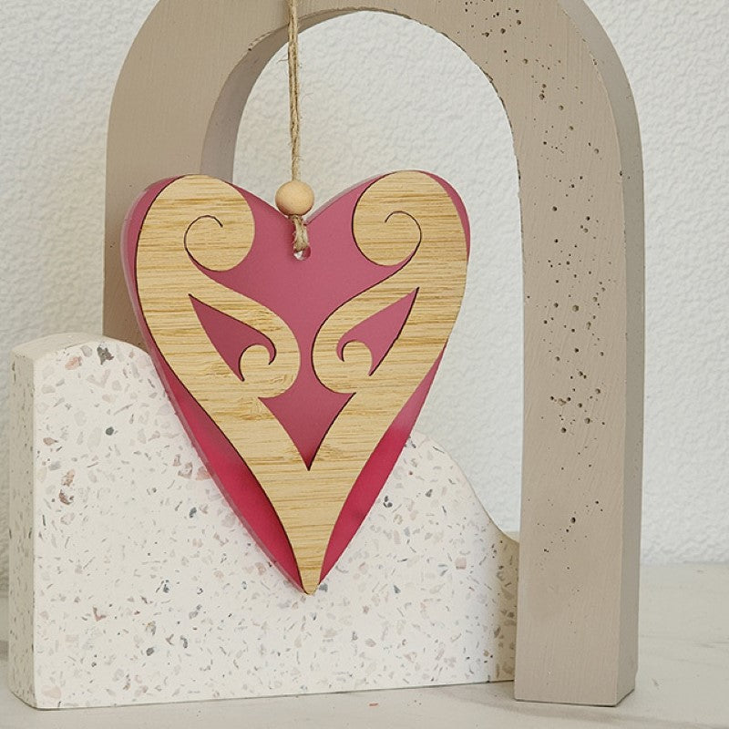 Pink satin acrylic heart ornament with Koru design, symbolizing love and new beginnings, perfect for gifting and decor.