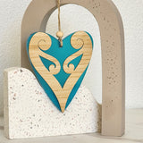 Teal satin acrylic heart ornament with koru design, perfect for home decor and as a thoughtful gift.
