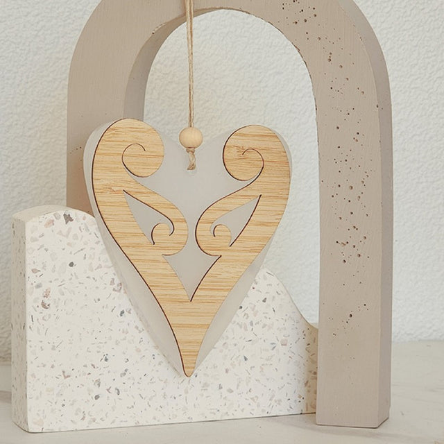 Elegant white satin acrylic heart ornament featuring a Koru design, perfect for modern decor or thoughtful gifts.