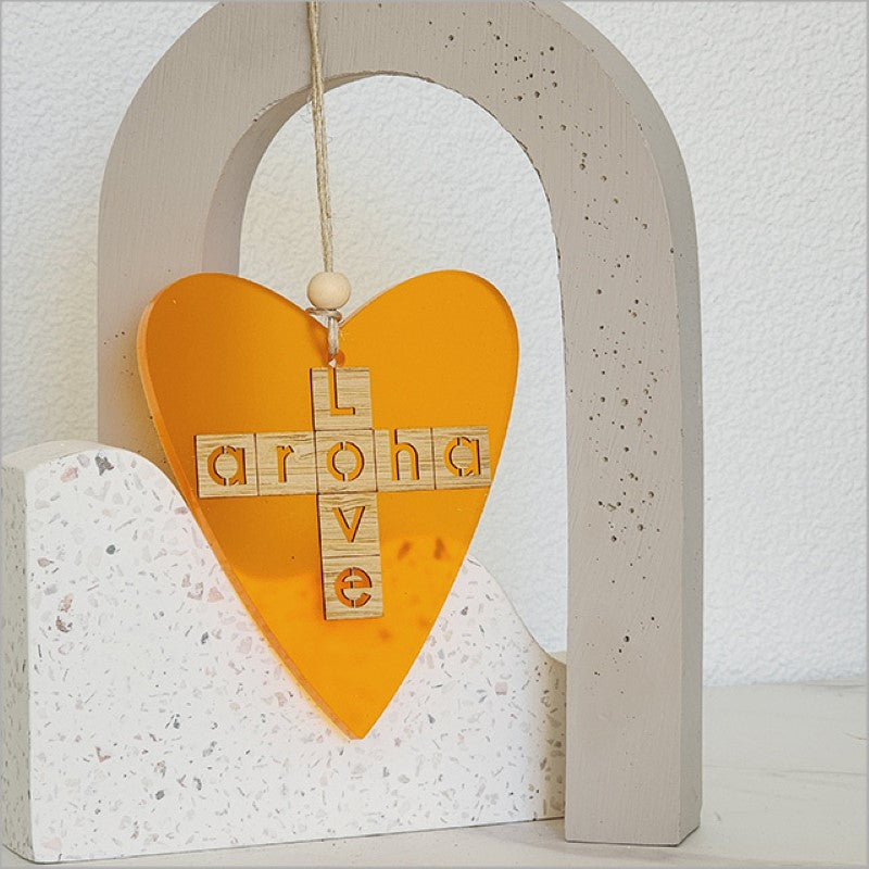 Heart-shaped hanging ornament in vibrant orange satin acrylic, symbolizing love, perfect for home decor and gifts.