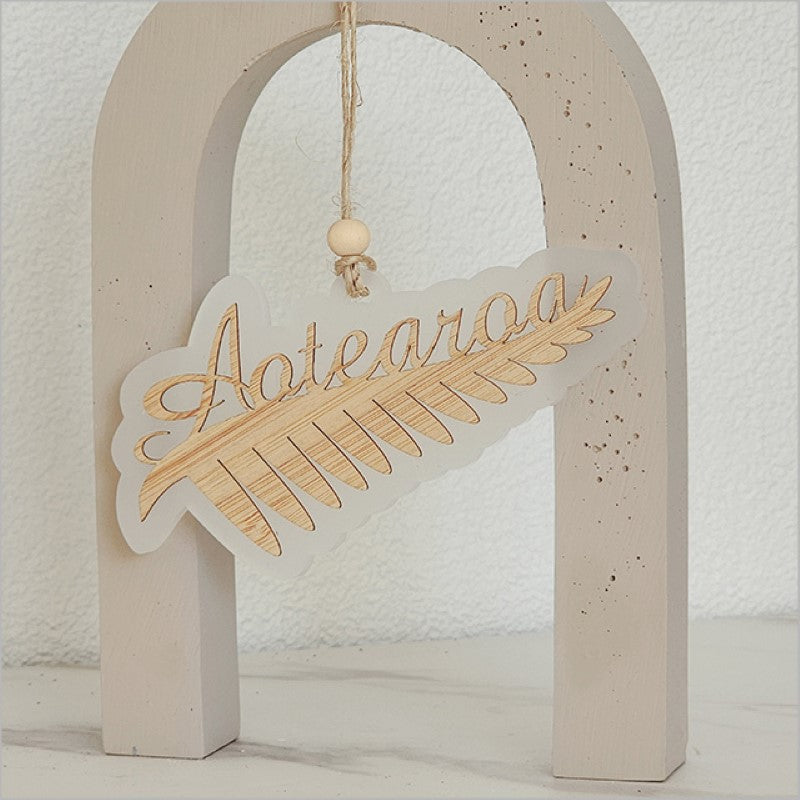 Stunning white satin acrylic hanging ornament featuring a laser cut silver fern, celebrating New Zealand's beauty.