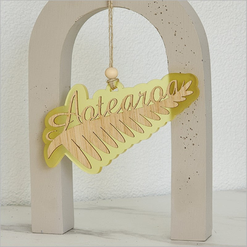 Yellow satin acrylic hanging ornament featuring a silver fern design, symbolizing New Zealand's beauty and culture.