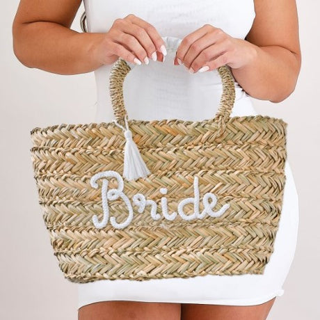 Stylish rattan bag for brides, featuring 'Bride' lettering and white tassels, perfect for hen party essentials.