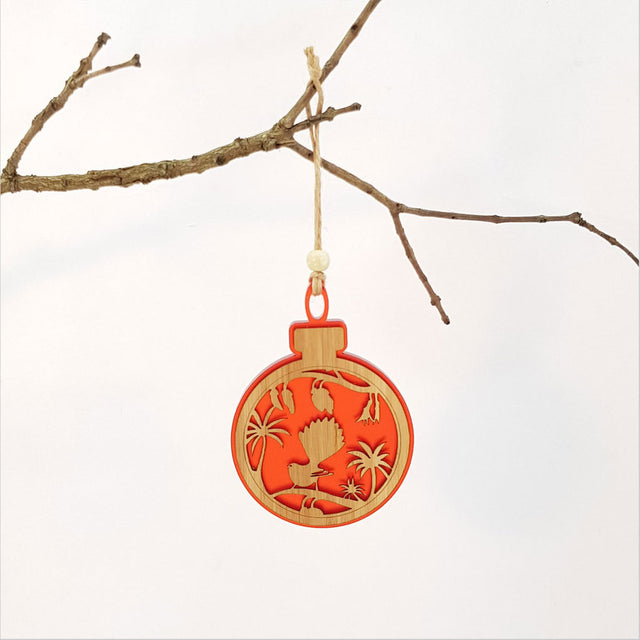 Red satin acrylic hanging ornament featuring a fantail on a kowhai branch, beautifully laser-cut for elegant decor.