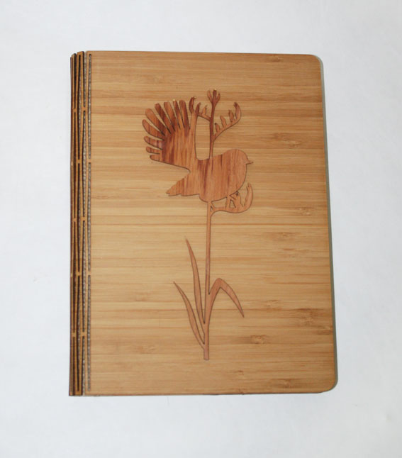 Elegant notebook featuring a fantail on tall flax, crafted from NZ Silver Beech and Bamboo Veneer, portable and stylish.