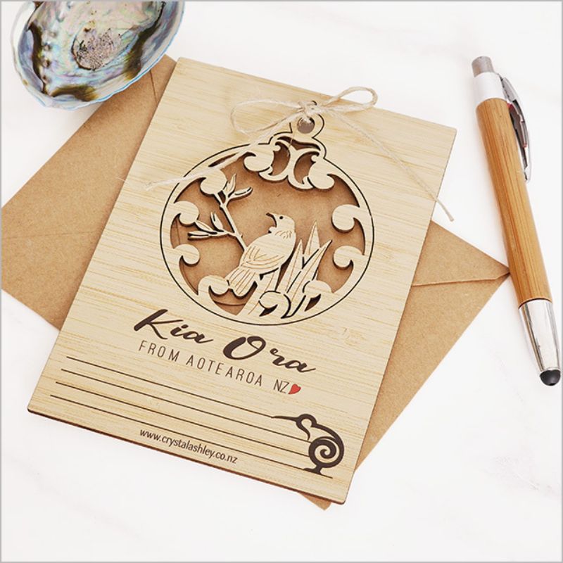 Eco-friendly bamboo postcard featuring vibrant Kia Ora Tui design, ideal for messages and unique hanging decor.