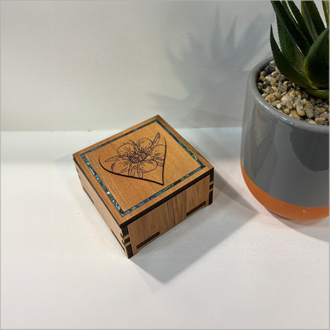 Small square trinket box with heart design, featuring Paua inlay, made from NZ veneer, measuring 80mm x 80mm x 45mm.