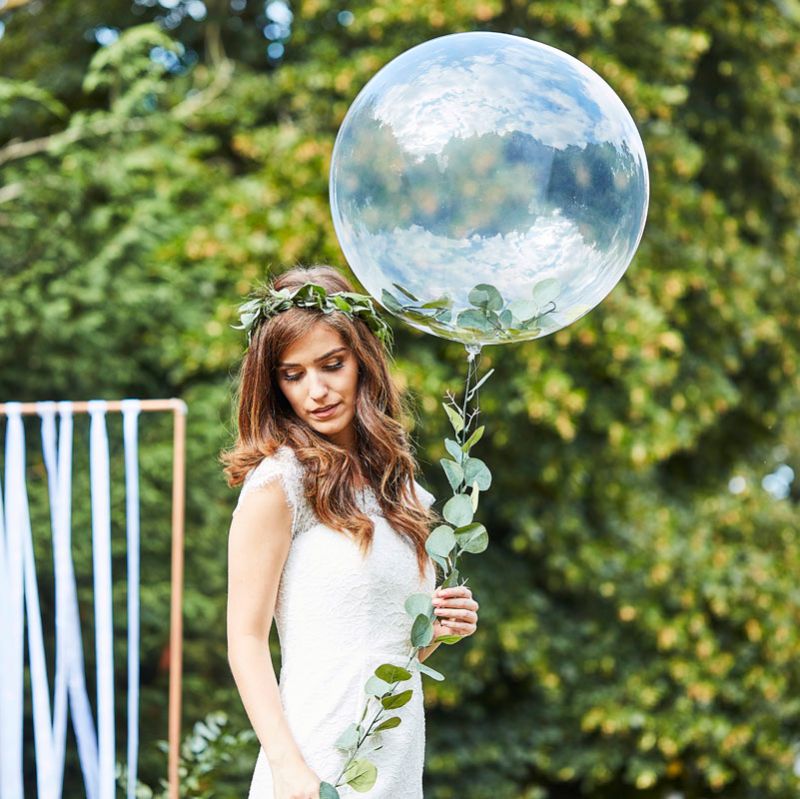 Clear orb balloon adorned with lush green vines, perfect for enhancing a natural wedding theme.