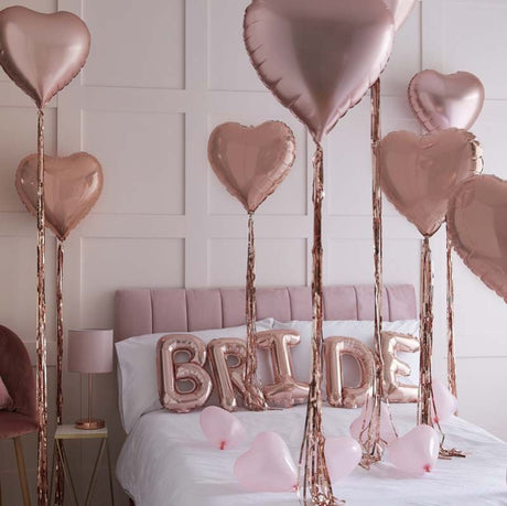 Rose gold bride and heart balloons kit for hen party bedroom decoration. Includes 'BRIDE' bunting and tassels.