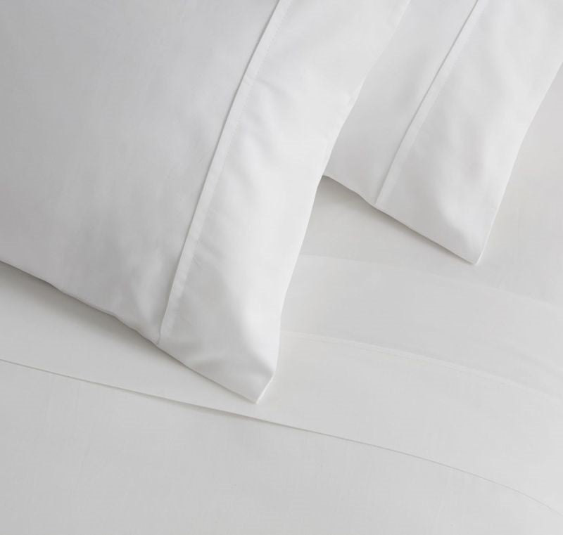 Luxurious 500TC white sateen sheet set by Baksana, featuring flat, fitted sheets and standard pillowcases, ethically made in Portugal.