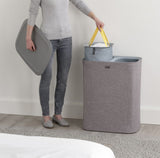 Joseph Joseph Tota 90-litre laundry separation basket in grey with two removable compartments for lights and darks.